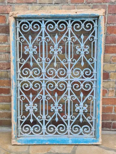 Ancienne fenêtre de Ryad Marocain avec sa grille en fer forgé et peinture écaillée bleu