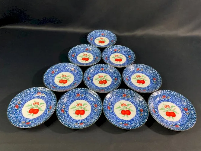 Suite de 10 assiettes à dessert en porcelaine signée à décor de fruits