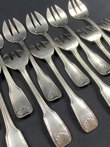 Suite de 12 fourchettes à huîtres en métal argenté modèle coquille Louis XV